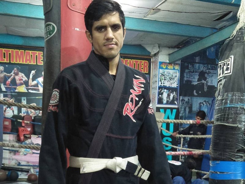 Amjad Khan in a black gi and white belt in a Lahore fight gym