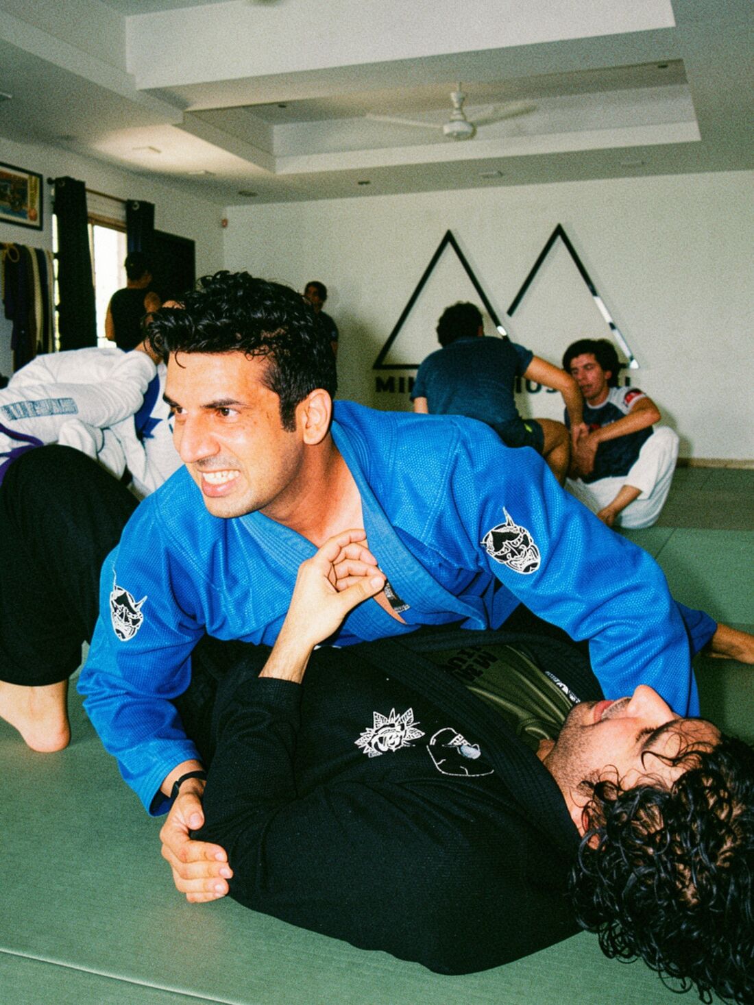 Sparring at Mikado Jiu Jitsu, with the mountain logo on the wall behind